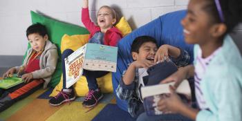 4 kids on bean bag chairs reading and laughing