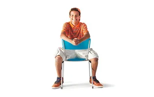 boy sitting backwards on blue chair