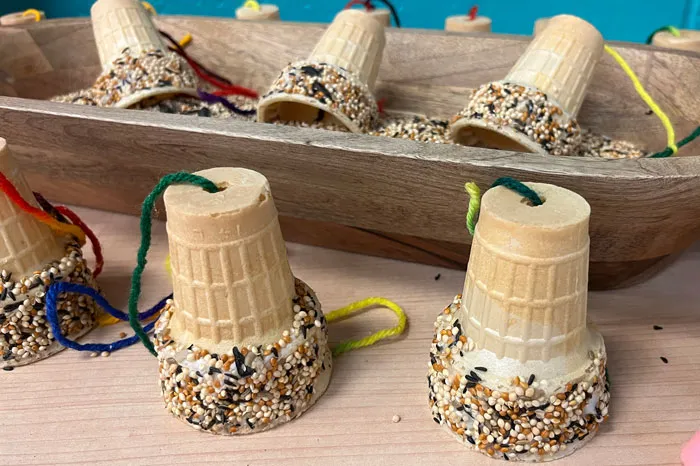 Youth activity ice cream cone bird feeder. Six upside down ice cream cones with yarn coming through the bottom of each cone, and birdseed on the rims.