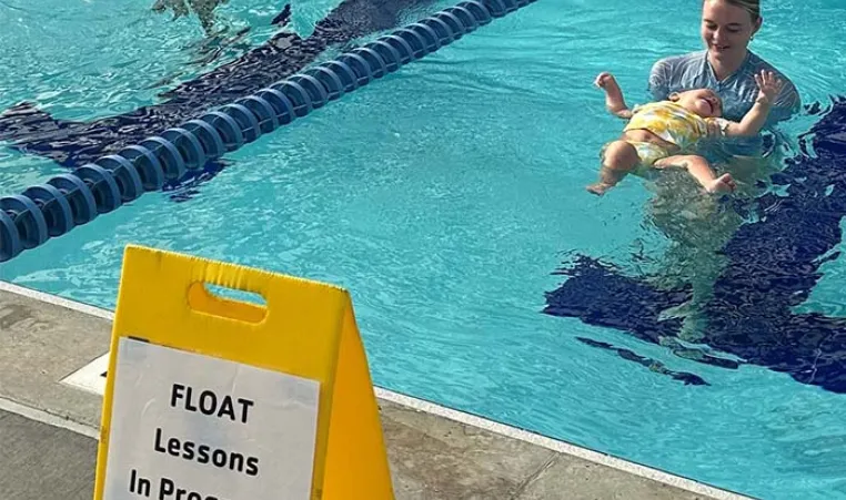 Instructors teaching toddlers to swim in the YMCA of the Suncoast pool.